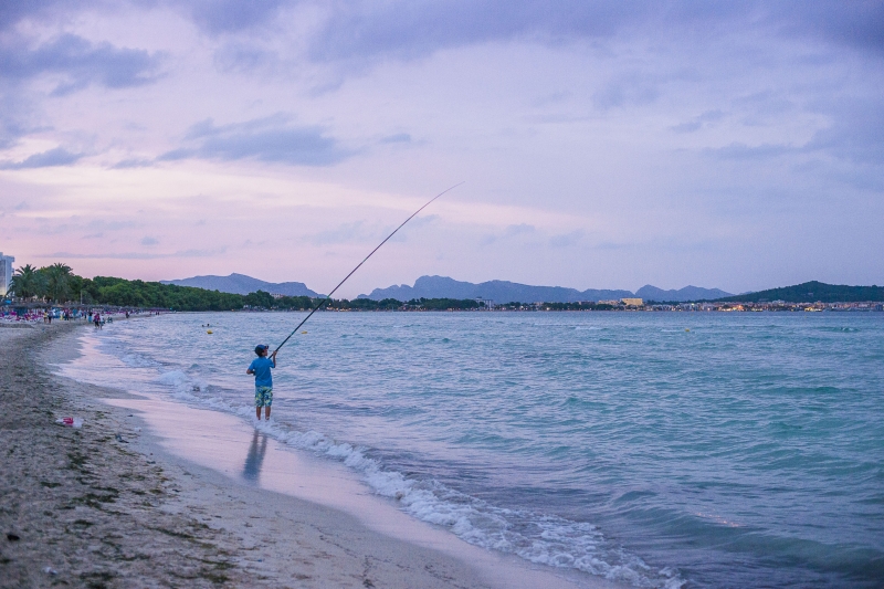 Person sailing on a shallow stretch of beach