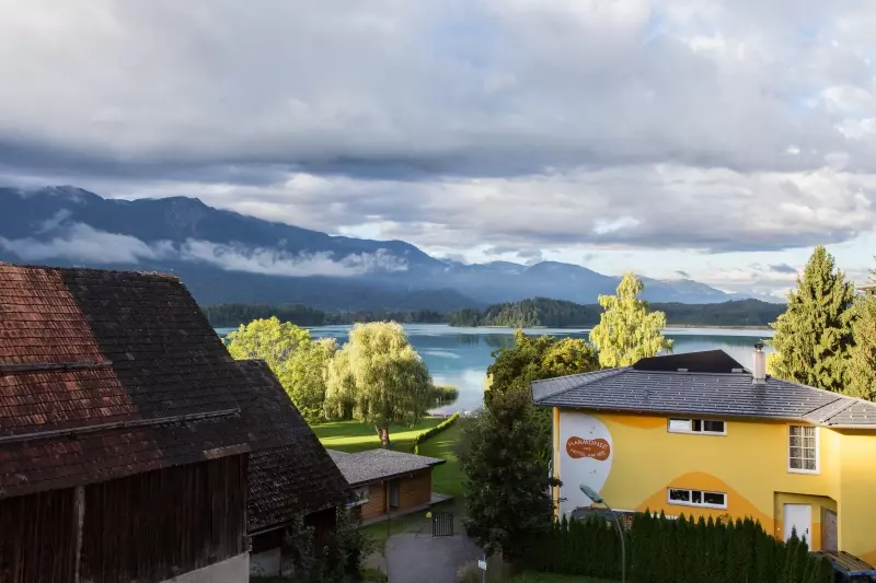 Faakersee with forested mountains