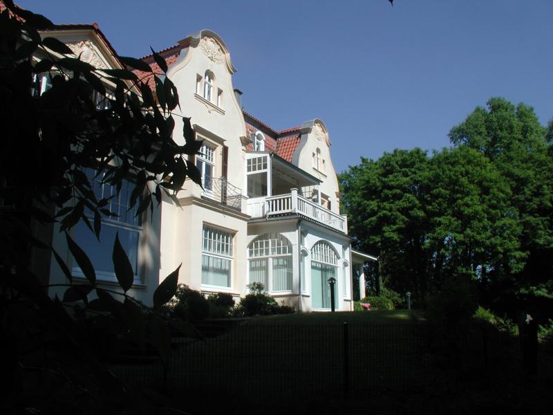 White villa with balcony and garden