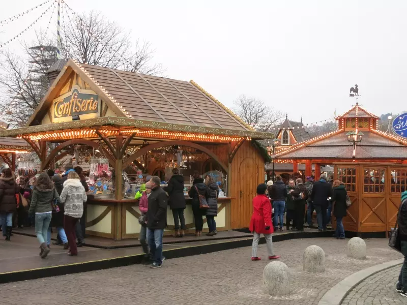 Illuminated Christmas market booths with visitors