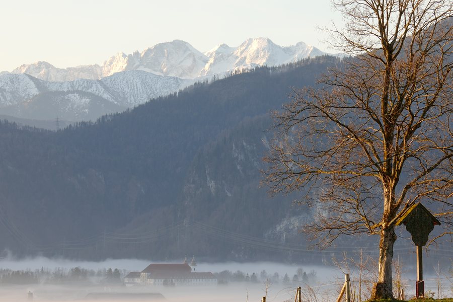 File:Der Kochelsee liegt unter einer geschlossenen Nebeldecke, davor Kloster Schlehdorf und einige Karwendel Gipfel im Hintergrund.jpg