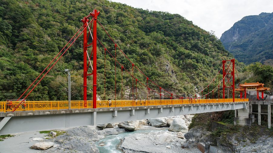 Pudu Bridge in Taroko Gorge in front of forested mountains in Taiwan