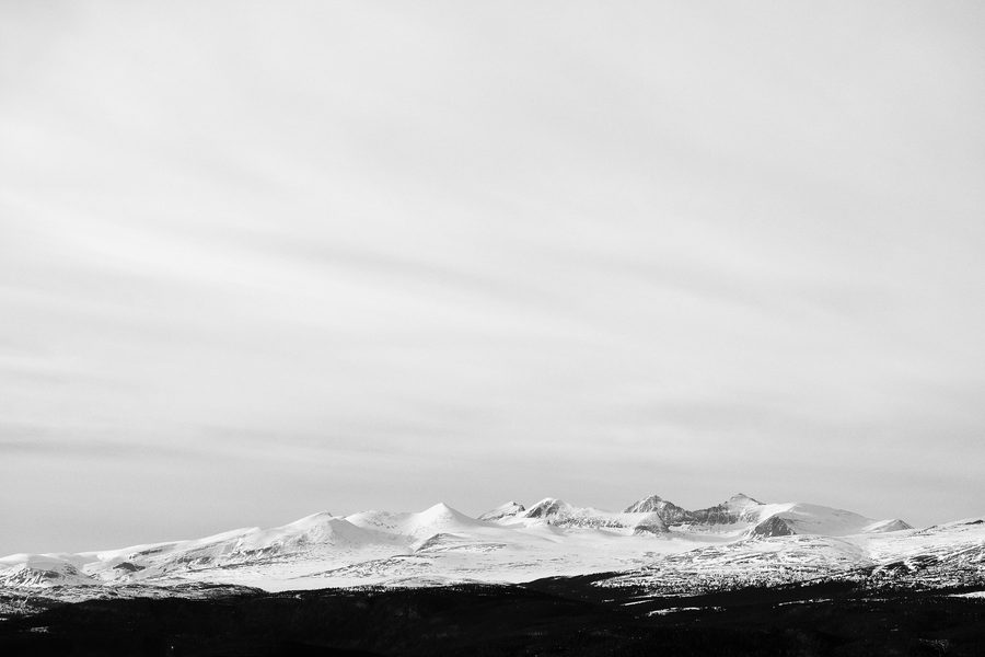 Mountain peaks of Rondane National Park under a bright spring sky.