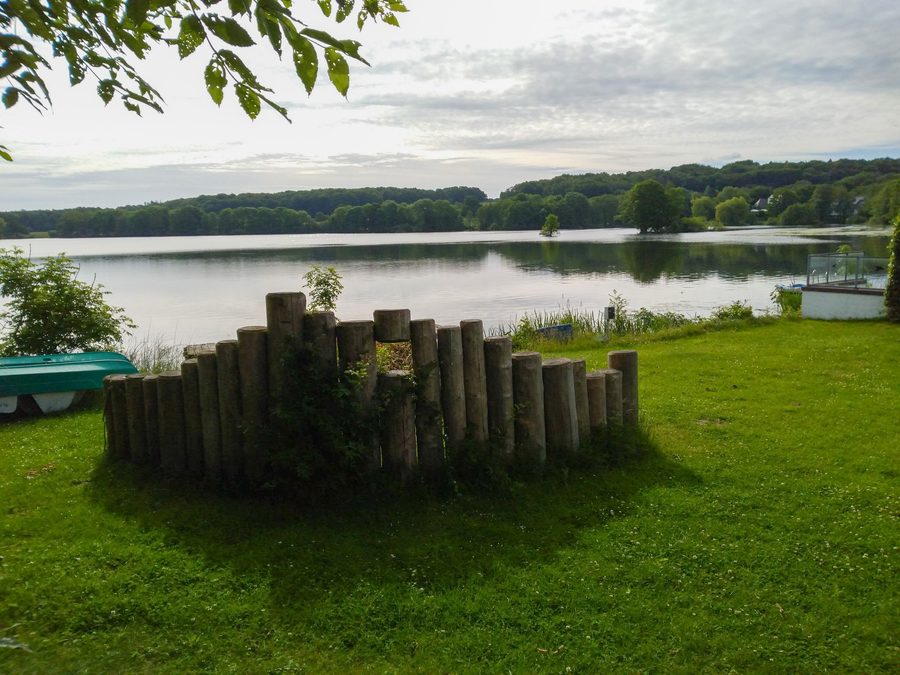 Western shore of Lake Bistensee with the forests of the Hüttener Berge in the background