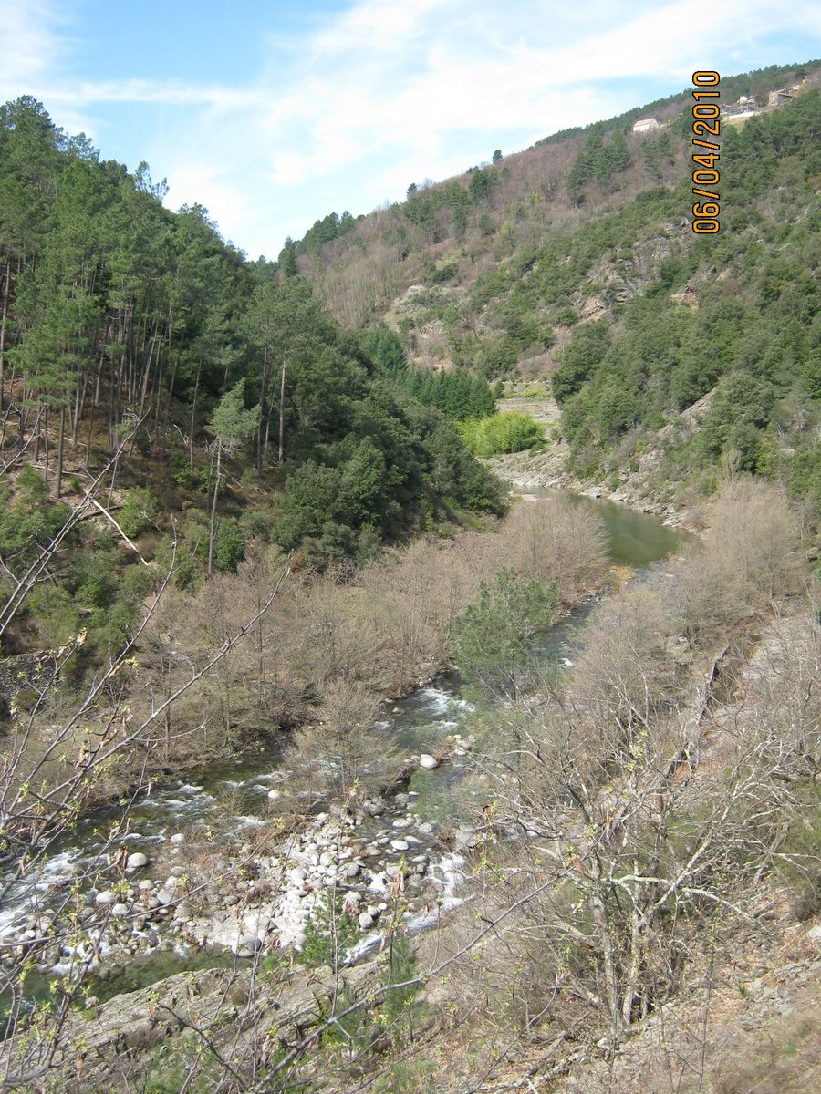 Landscape of the Drobie Valley in the Ardèche with wooded mountain slopes and scattered houses