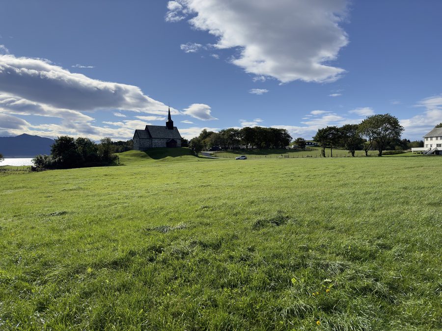 Old Edøy Church with fields and the historic Edøy farm on Edøya