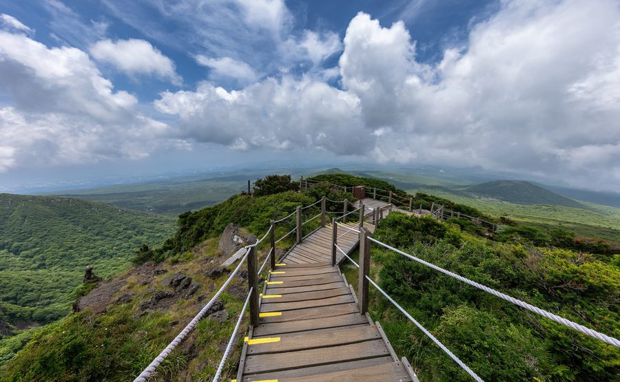 Wooden staircase on the Yeongsil Trail with the Hallasan mountains on Jeju