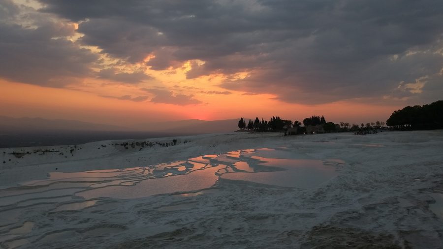 Pamukkale travertine hills viewed across the surrounding landscape at golden hour