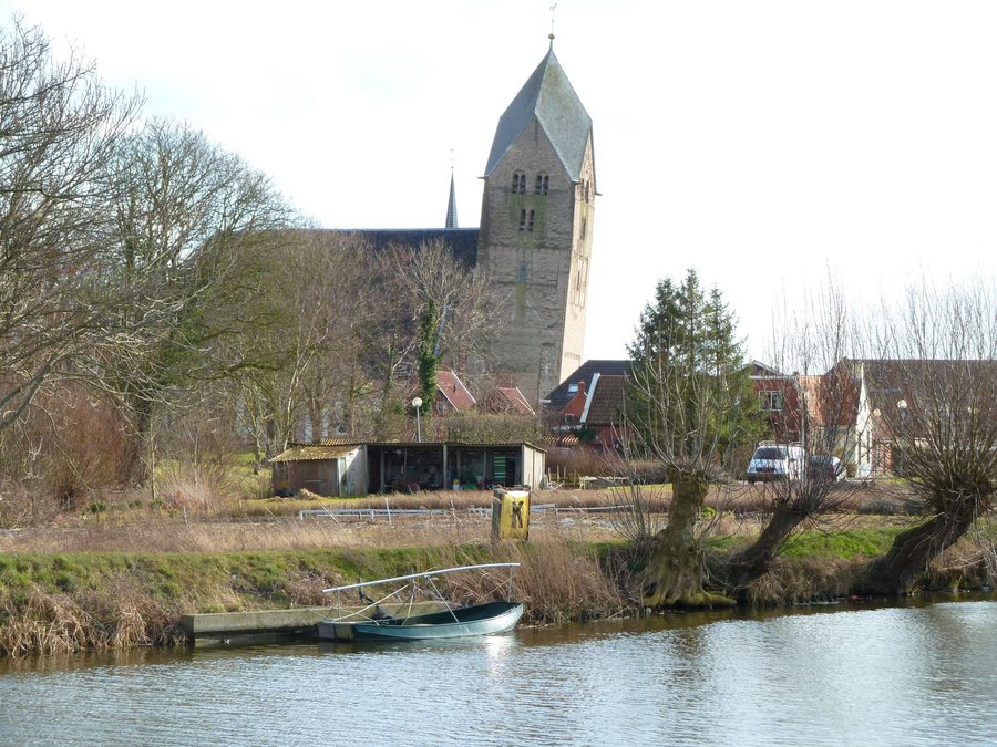 Walfriduskerk in Bedum mit schiefem Kirchturm, gesehen über das Boterdiep