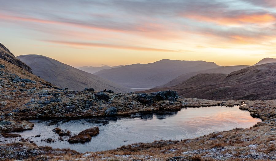 Small lake between mountains in the Scottish Highlands at sunrise