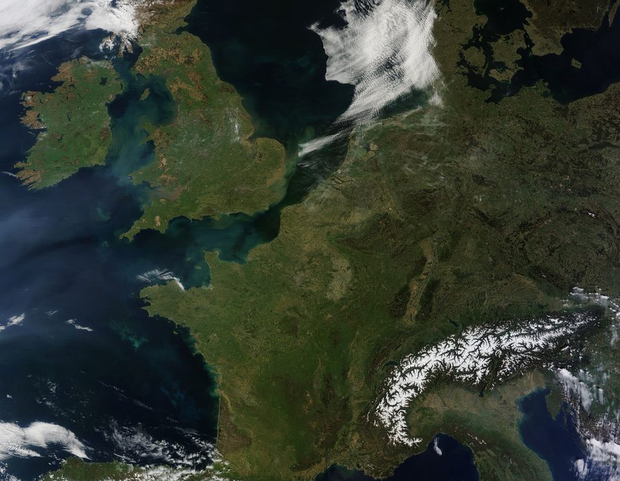 Satellite image of Western Europe with cloud bands over land and sea.