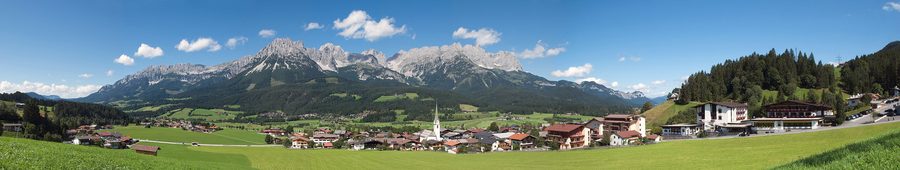 Mountain village Ellmau with green slopes and a wide valley in summer.