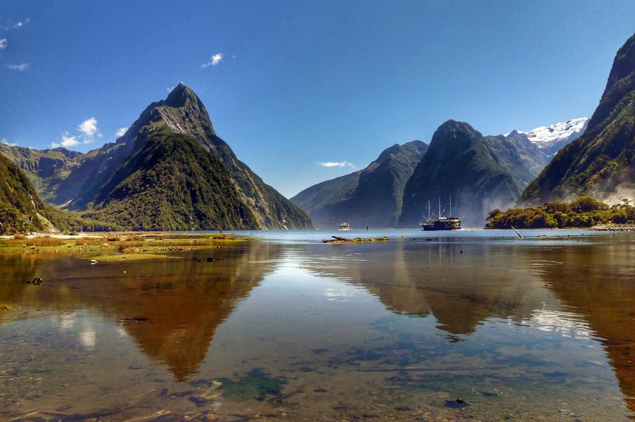 Milford Sound in New Zealand with steep rock faces shaped by glaciers, waterfalls, and dark fjord water