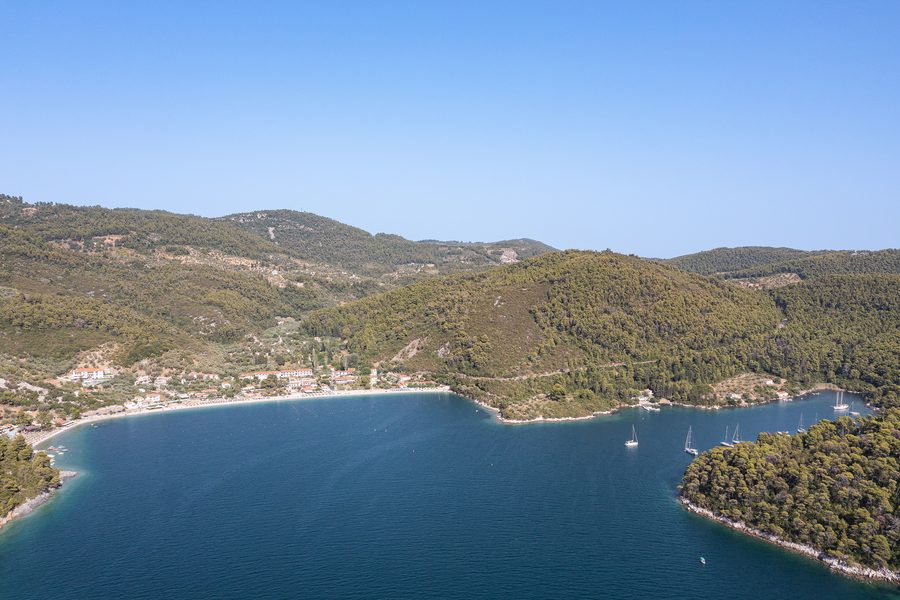 Aerial view of Panormos beach on Skopelos with turquoise water and a wooded coastline
