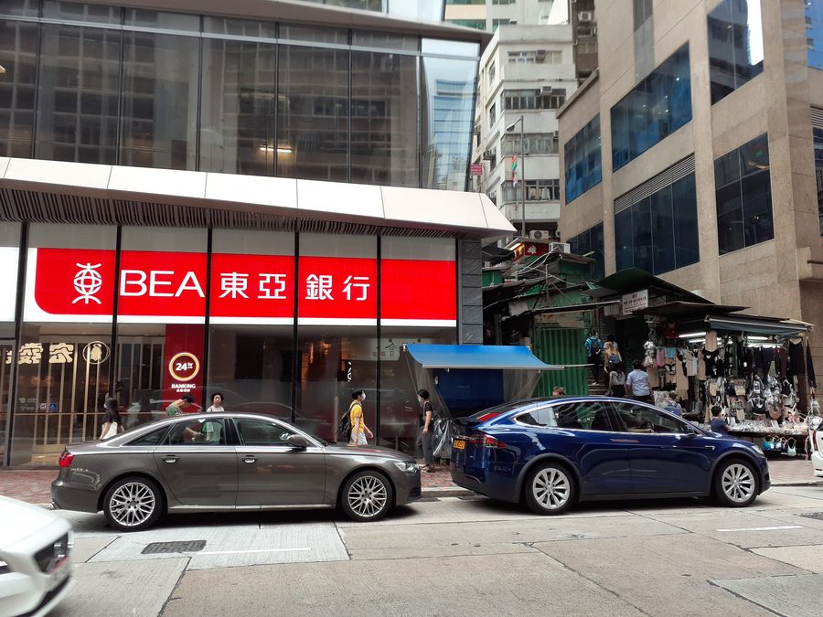 Street scene on Queen's Road Central in Hong Kong with a branch of the Bank of East Asia.