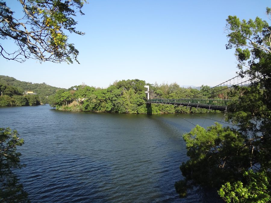 Suspension bridge over Mingde Reservoir in Touwu, surrounded by green mountains