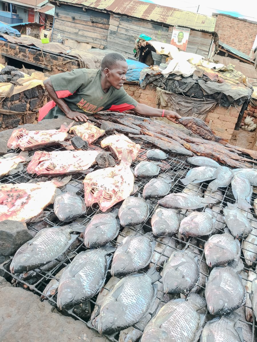 Fish seller with traditionally smoked and fresh fish at Ggaba Landing Site in Uganda