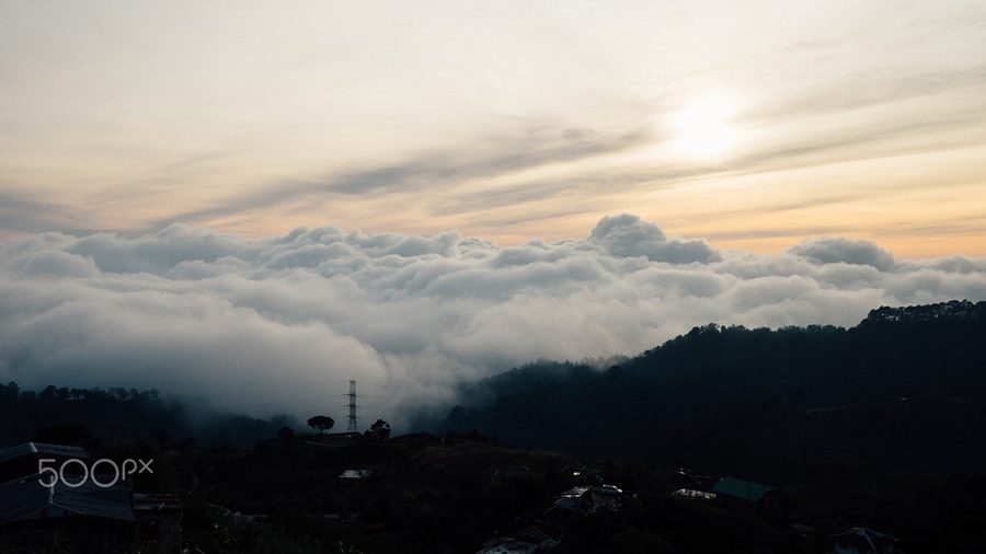 View over a green coastal landscape with water and a distant coast in Southeast Asia.