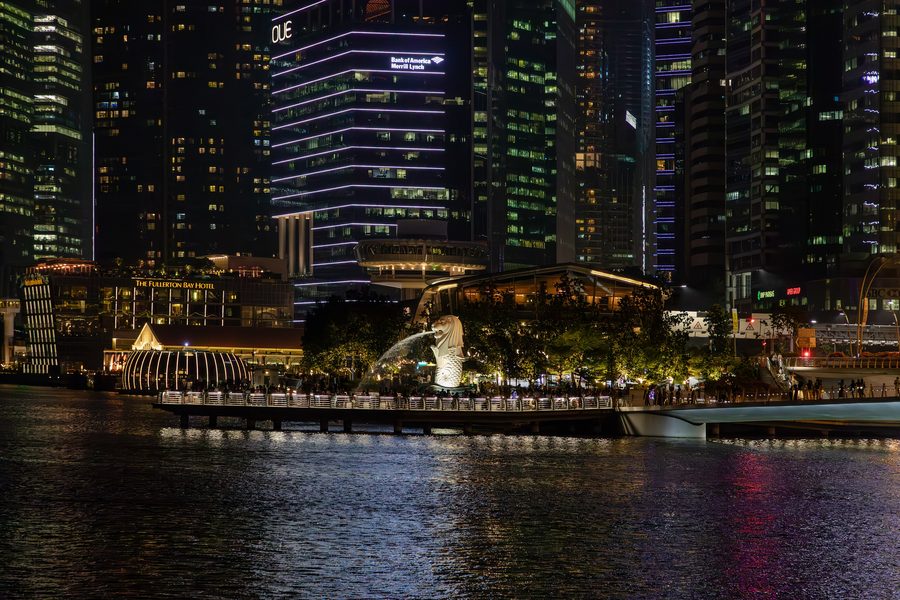 The Merlion statue in Singapore in front of the skyline.