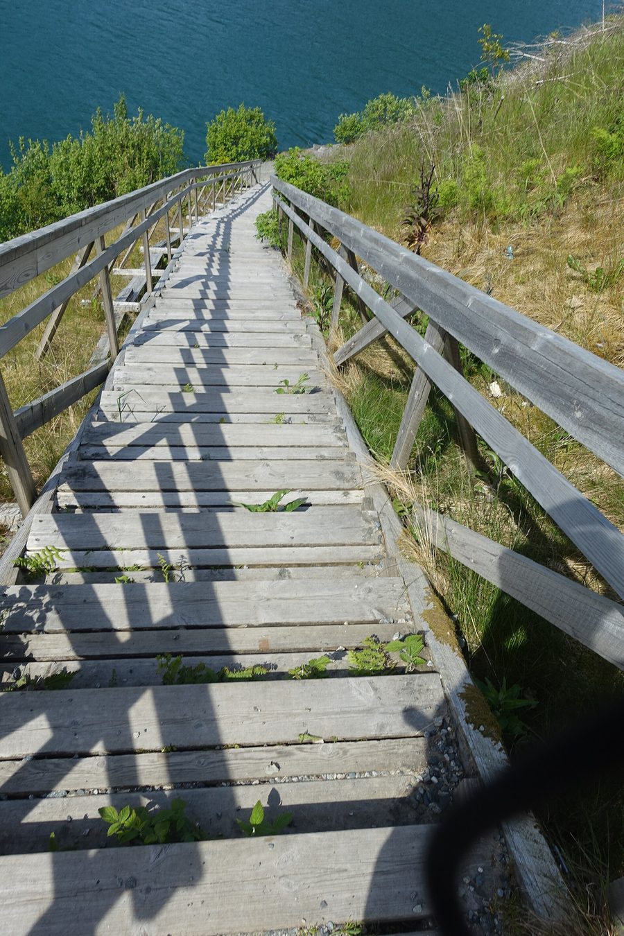 Wooden staircase at Langfossen leading down to the Åkrafjord in front of steep mountain scenery