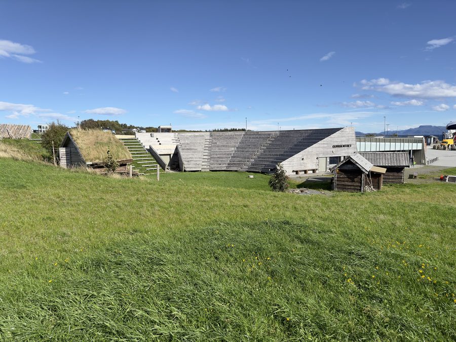 Ferry quay and coastal landscape on Edøya with outdoor stage at Gurisentret
