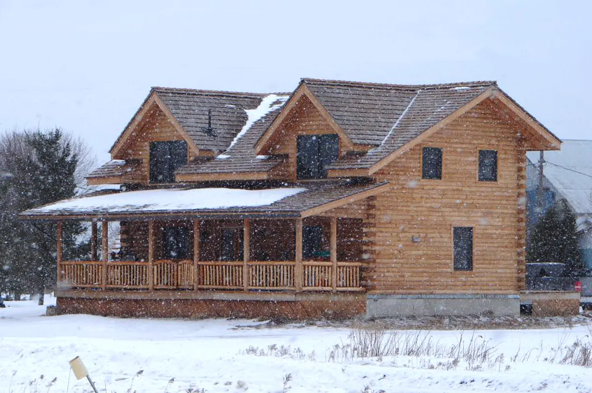 Modern wooden holiday home in the snow with covered wooden terrace